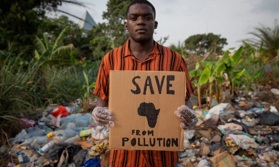 a-boy-holds-a-save-africa-from-pollution-sign-an-2023-11-27-05-03-26-utc
